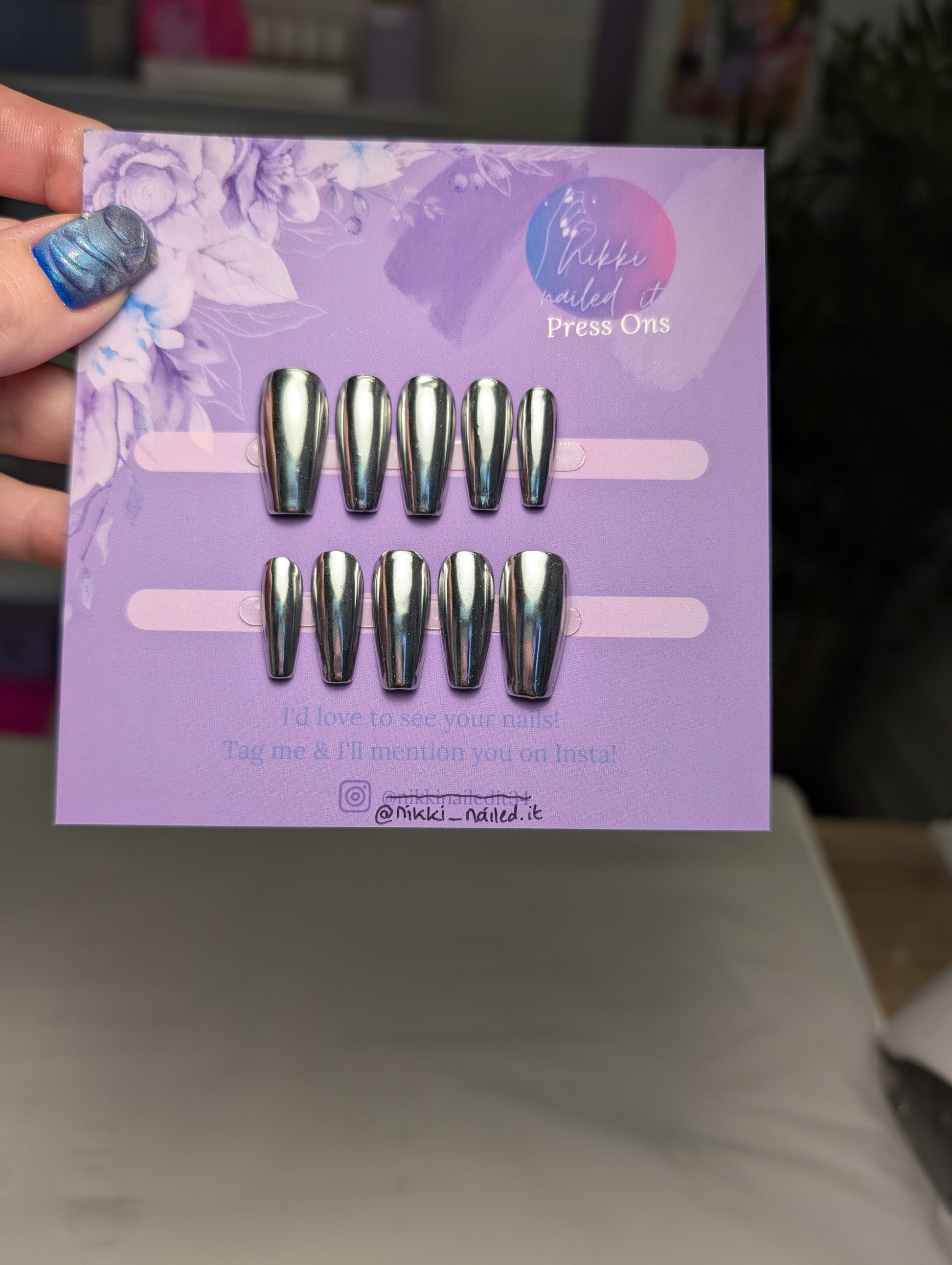Hand painted Chrome Silver Press On Nails set displayed on a purple card, featuring reflective chrome finish and short coffin shape.