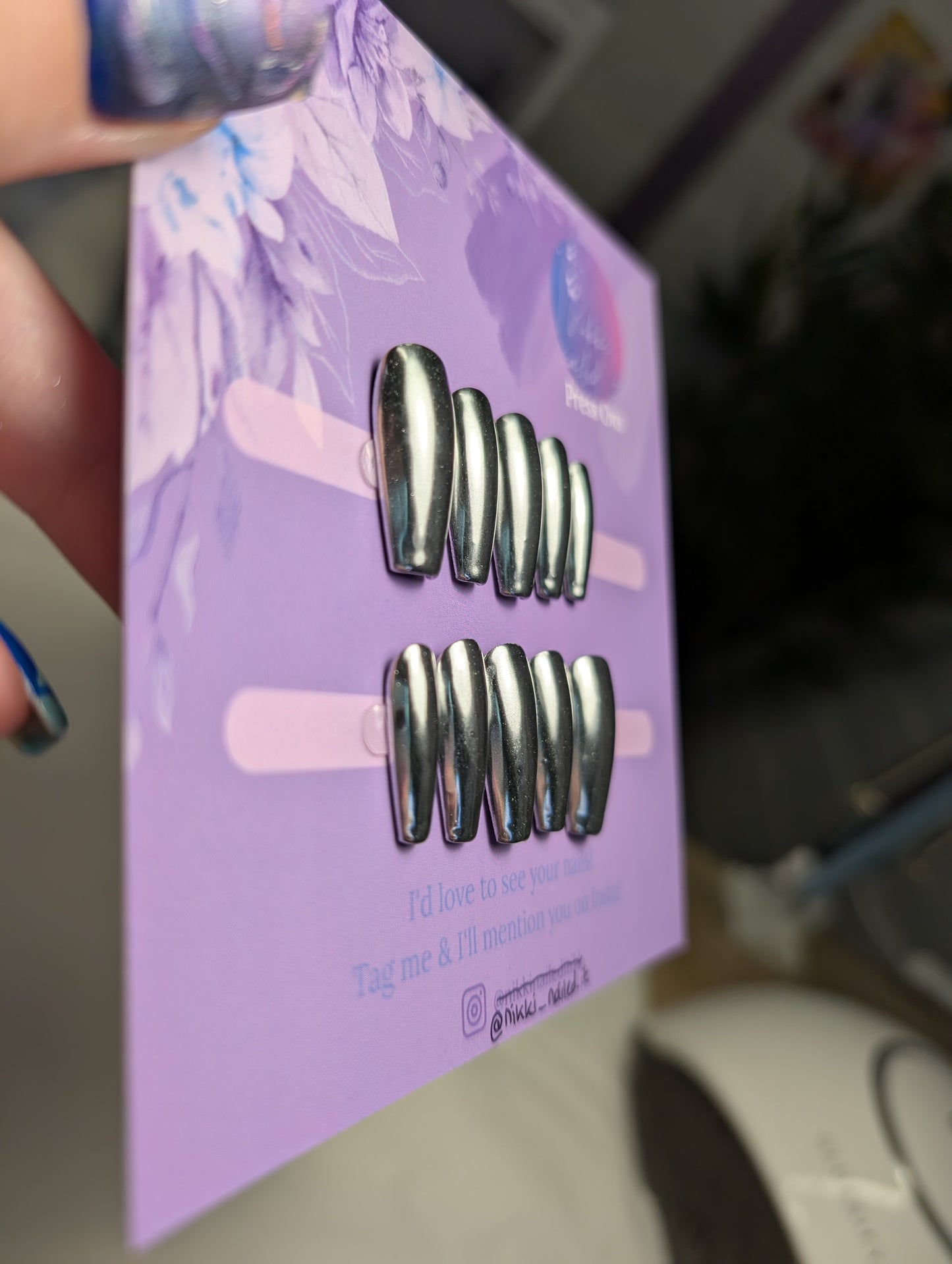 Chrome Silver Press On Nails displayed on a floral packaging, showcasing hand painted reflective design.
