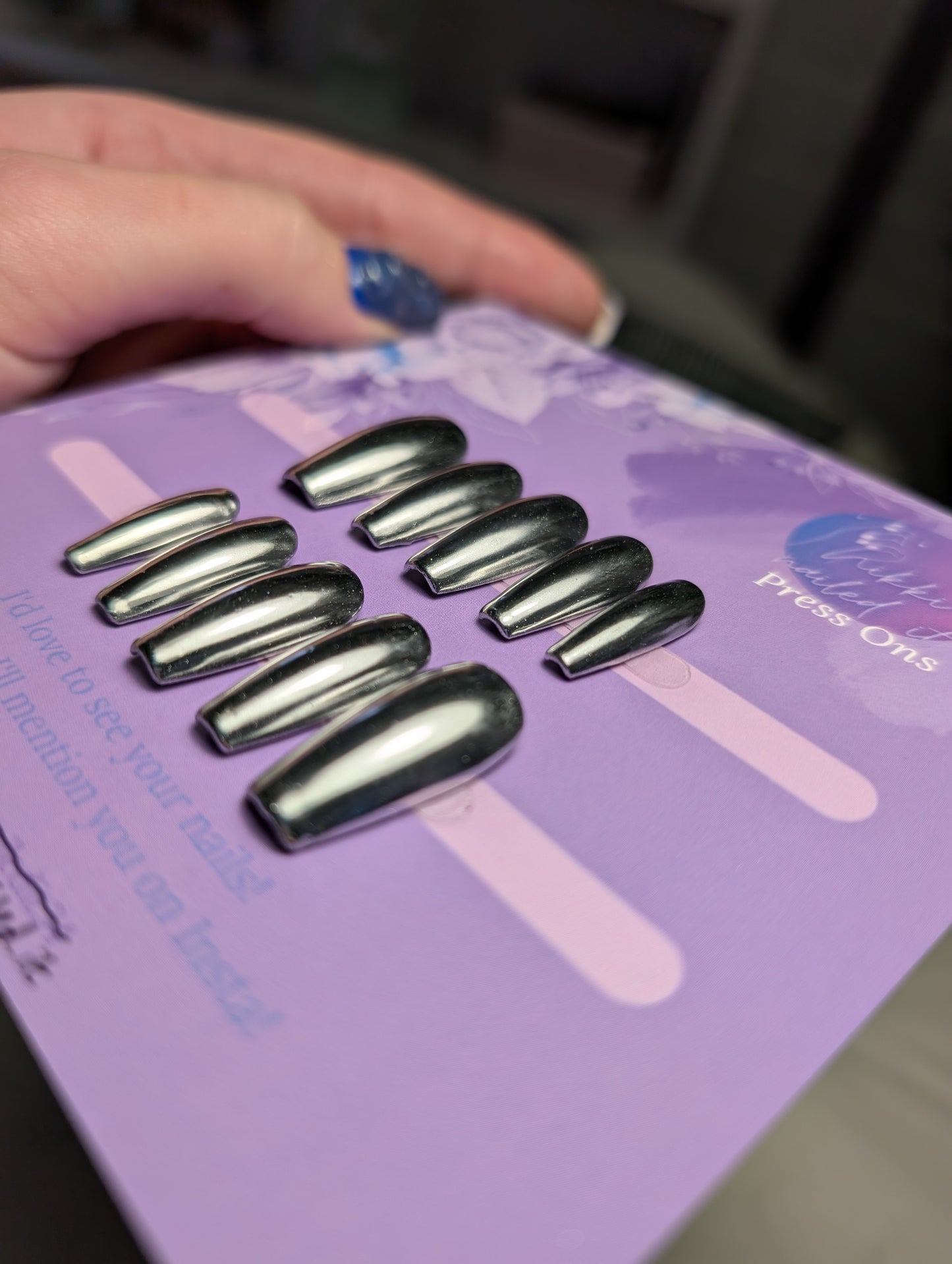 Chrome Silver Press On Nails displayed on a purple card, featuring a hand painted silver chrome design for Halloween or fall.