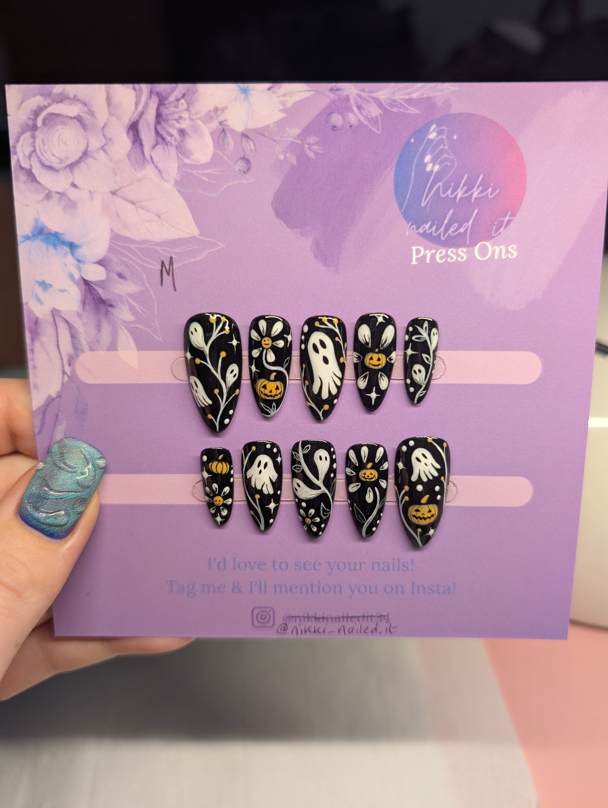 Hand painted Halloween Monochrome Press On Nails on display, featuring ghosts and pumpkins on a black background.